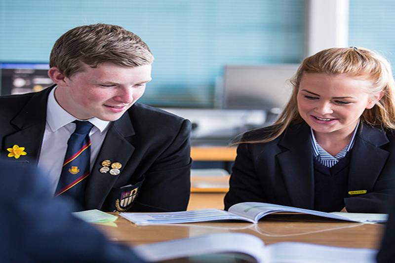 two school children in uniform at desk